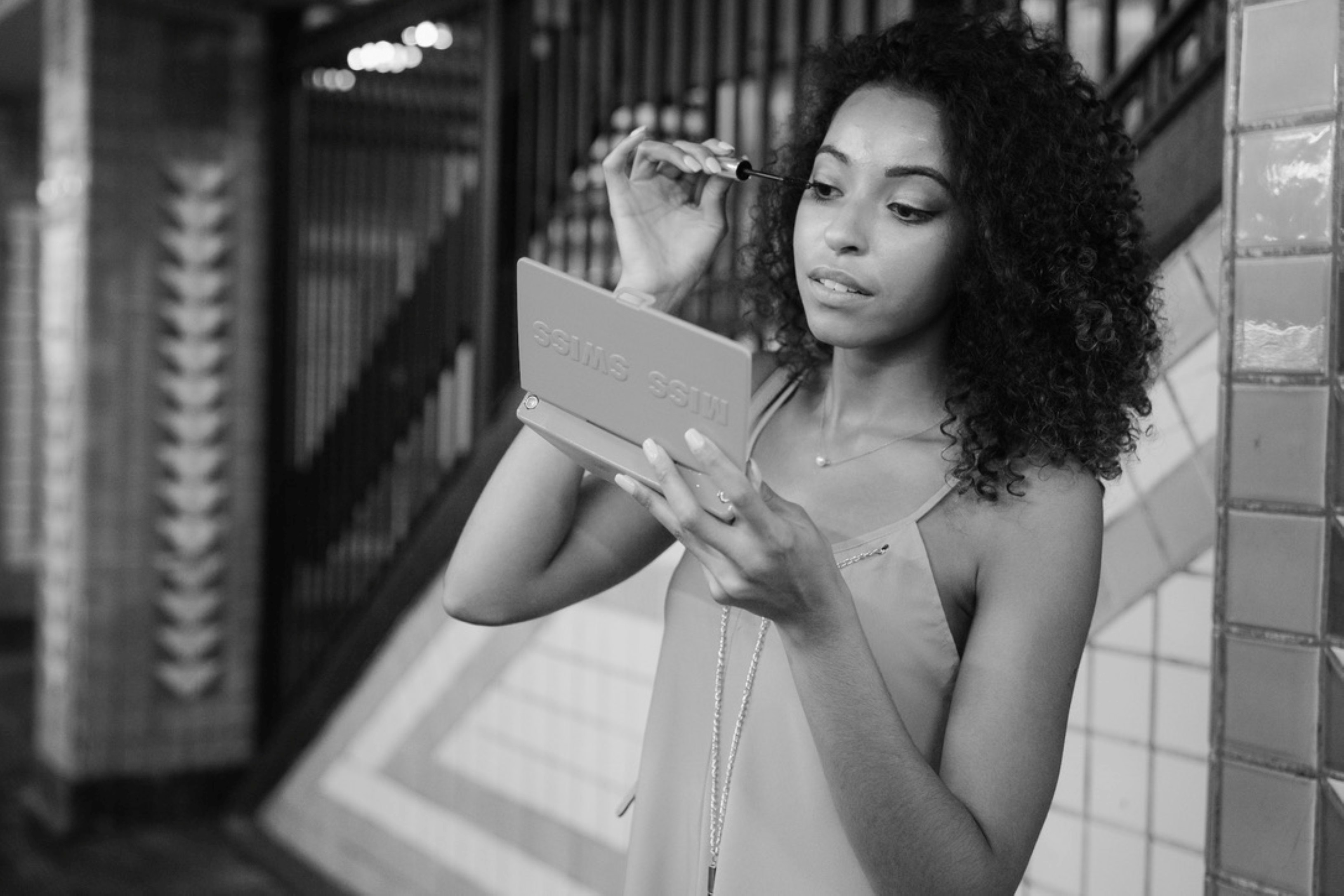 woman in white tank top holding white box